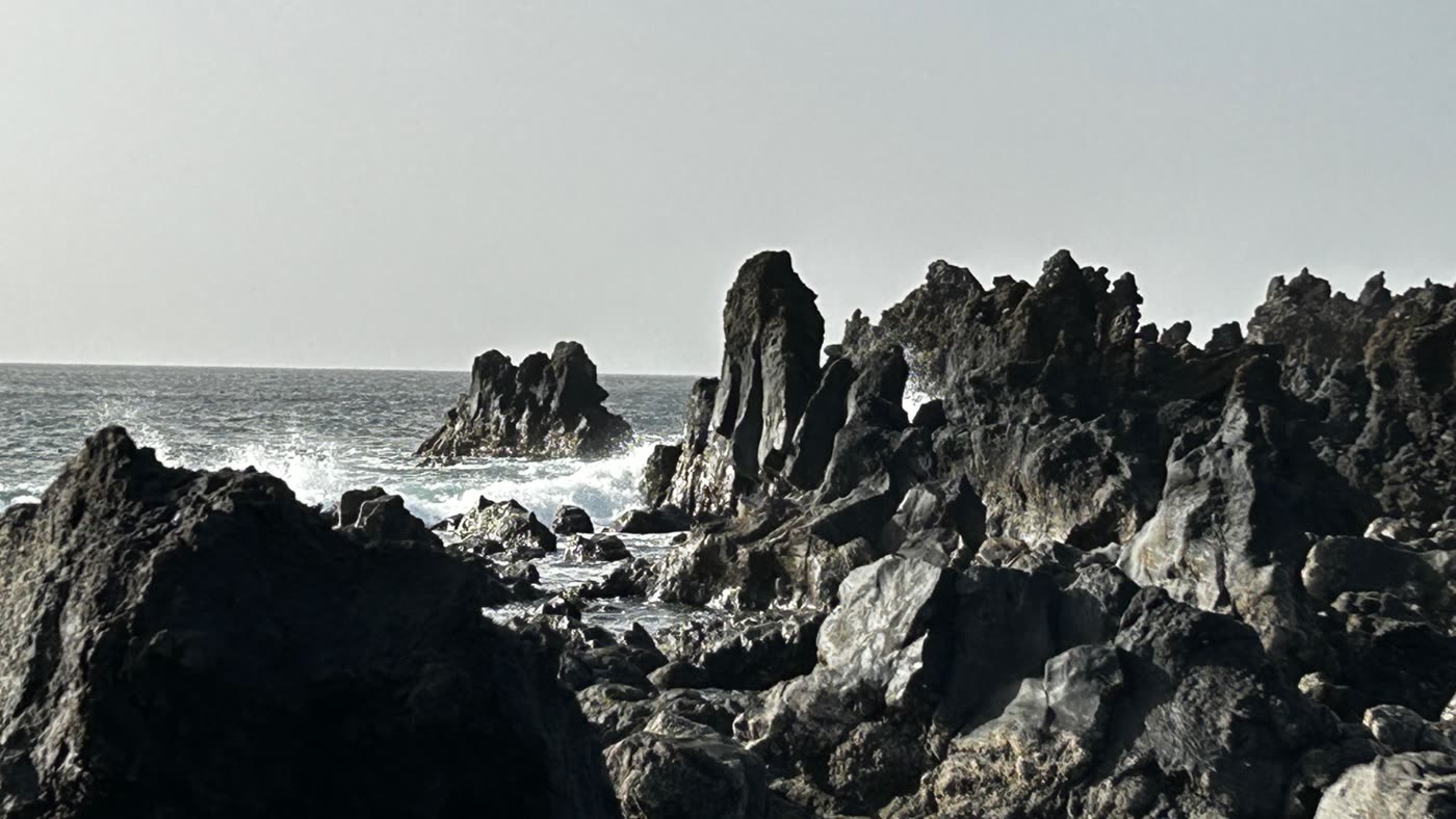 Massi appuntiti ai lati della spiaggia nera